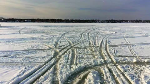 Aerial low angle view flying over truck tracks left on the frozen river Stock-Footage 164346273