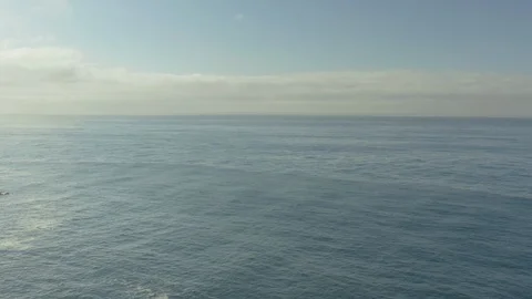 Aerial low decend pullback over the sand on the beach over rocks crashing on the Stock-Footage 96042939