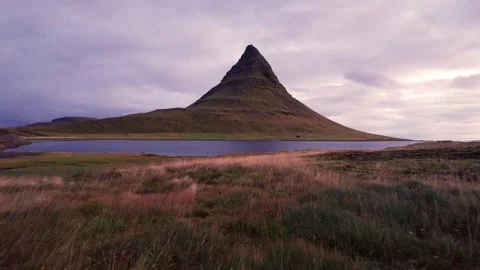 Aerial Low Flight Over Grass Toward Kirkjufell Iceland Famous Mountain Stock Footage 256715501