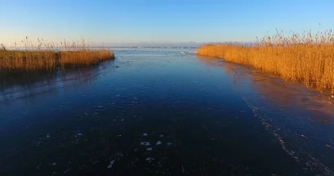 Aerial. Low flight over ice covered lagoon away from shore 動画素材 101550380