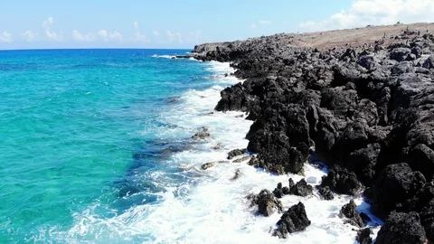 Aerial low fly over beach volcanic rocks and azure blue sea, Crete Stock Footage 100671880