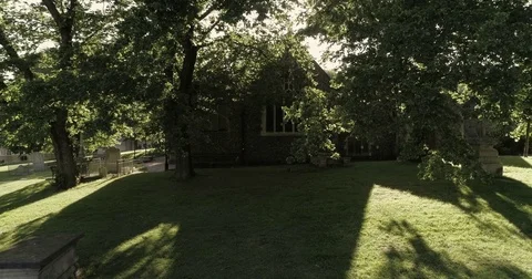 Aerial low flying backwards view of tombstones in a small cemetery Stock Footage 77747593