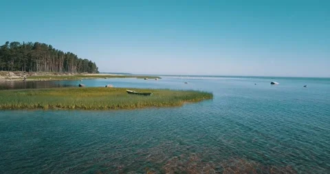 Aerial low-level pass over the shallow water of the sea bay on a sunny day Stock Footage 146701255