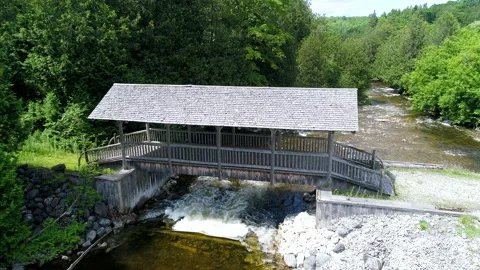 Aerial Low Over Covered Bridge Towards Fly Fisherman Walking In The River Stock-Footage 195984875