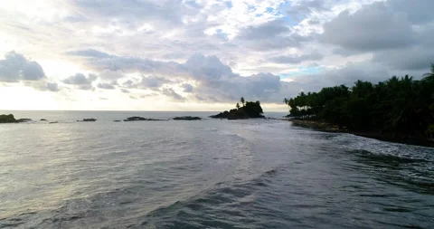 Aerial Low Over Ocean Surf On Jungle Coastline With Cloudy Sunset Colors Video stock 135307074