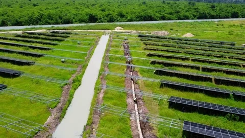 Aerial low view of cable trench digging at solar farm with stagnated water on Stock Footage 299177876