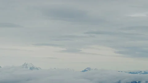 Aerial of lower clouds and snow mountain peaks at base of frame Stock Footage 154987879