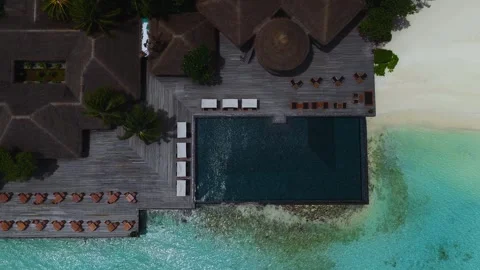 Aerial Maldives resort with infinity pool, cabanas, and Indian Ocean Stock Footage 337704252