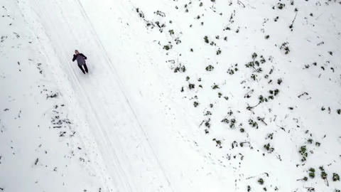 Aerial of man going for a run in winter Stock-Footage 147293215
