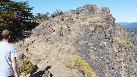 Aerial of man reaching mountain summit discovering landscape of lakes 库存影片 125859170