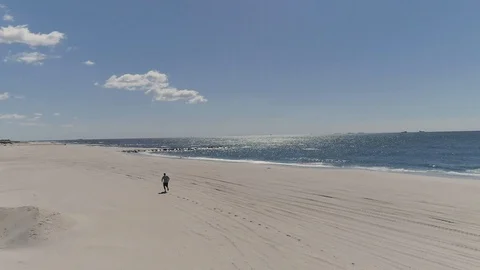Aerial of man running on the beach in the hamptons Vídeos de archivo 106178587