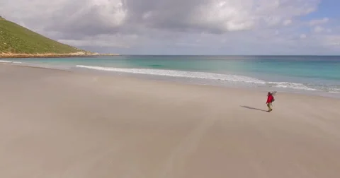 Aerial of Man Walking Alone on Empty Beach, Cape Town Stock Footage 60114943