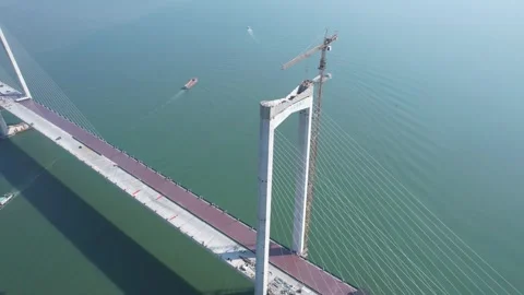 Aerial Massive Cable Stayed Bridge Construction Spanning Over Calm Blue Sea Stock Footage 342280010