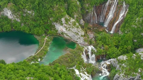 Aerial massive waterfall by lush forest lakes Stock Footage 126465405