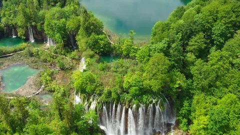 Aerial massive waterfall by lush forest lakes Stock Footage 126465481