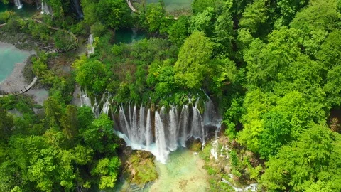 Aerial massive waterfall by lush forest lakes Stock Footage 126465553