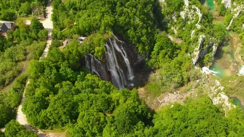 Aerial massive waterfall by lush forest lakes Stock Footage 126465572
