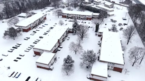 Aerial medium orbit of snow covered apartment complex and cars in parking lot Stock-Footage 331580722