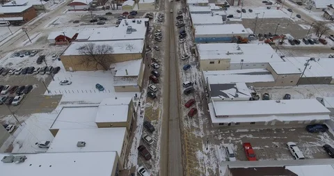 Aerial medium push across small town to frozen river Stock Footage 86297612