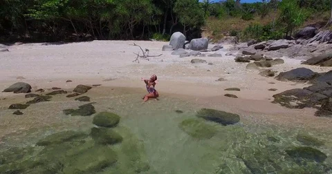 Aerial: Model posing on the beach on a wild island in the sea. Thailand. Phuket. Stock Footage 76726680