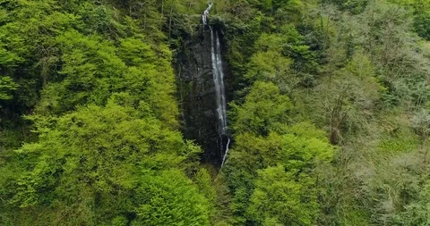 Aerial: Motion view of a waterfall in the mountainous forest 4K Stock-Footage 87912849