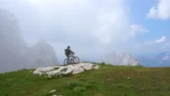 Aerial - Mountain Biker Looking At The View After Reaching The Summit Stock Footage