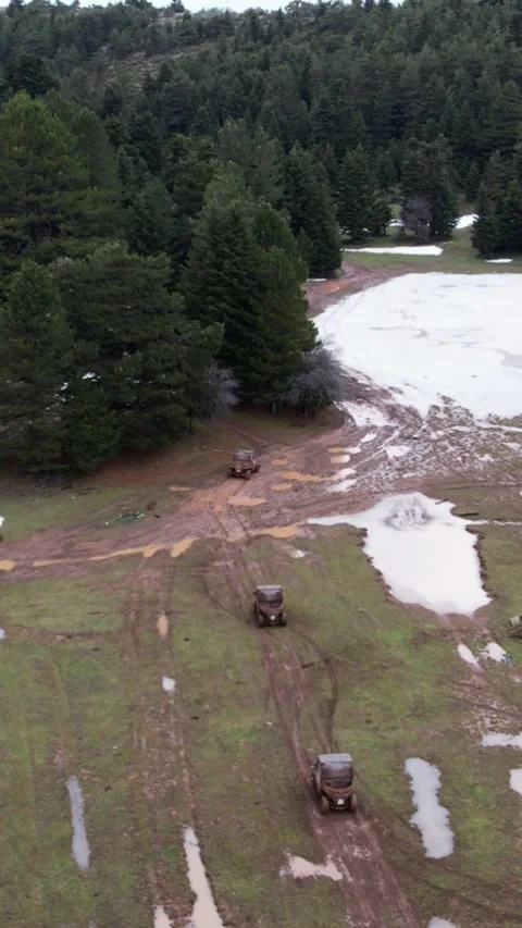 Aerial mountain clearing with muddy trails and ATV vehicles in forest Stock Footage 343992664