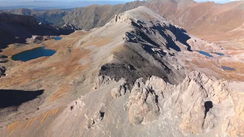 Aerial mountain flight above alpine lakes and rocky peaks Stock Footage 336017857