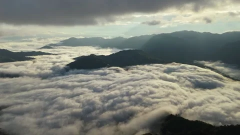 Aerial Mountain Landscape Above Clouds with Sun Rays Breaking Through Dramatic Stock Footage 329102907