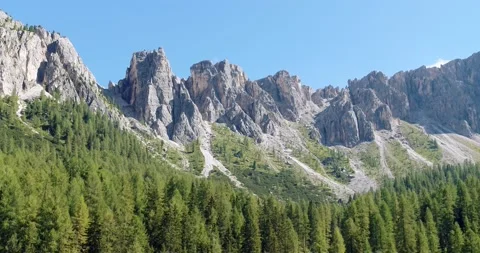 Aerial Mountain range in the Alps towering above Forest of pine trees. 4K Stock Footage 149395345