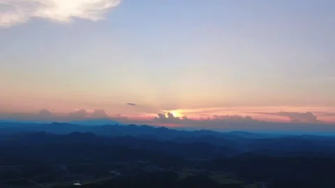 Aerial Mountain Ranges at Sunset with Distant City Highway Traffic Stock Footage 342326846
