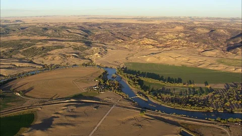 Aerial of mountain river flowing through field and trees, North Platte River Stock Footage 109470215