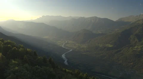 AERIAL: Mountain river running through beautiful green valley in misty evening Stock Footage 68105251