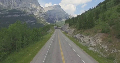 Aerial of mountain road passing through Canadian Rockies Stock Footage 69740106