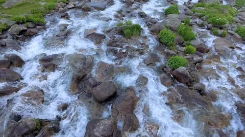 Aerial mountain stream rushes over rocks through alpine terrain - Alpine Creek Stockbeeldmateriaal 339435386