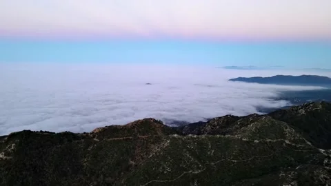 Aerial of mountains above low clouds at dawn Video stock 222269097