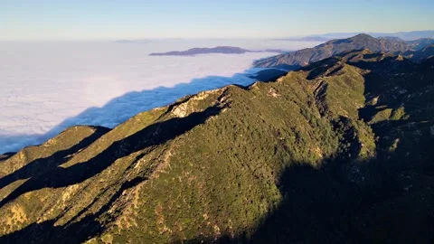 Aerial of mountains above low clouds at dawn Vidéo 302594718