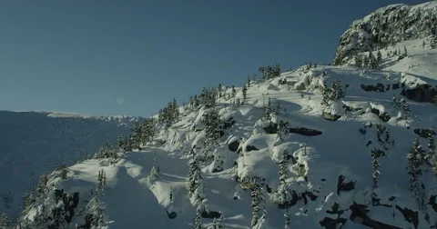 Aerial of mountains with cliffs and trees in deep winter 動画素材 78209560