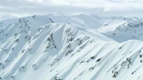 Aerial of mountains covered in snow with cloudy sky located in Iceland Stock Footage 124229735