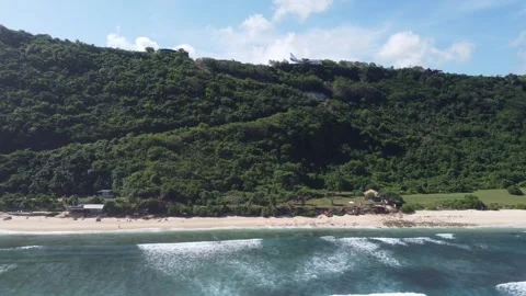 Aerial move left along beach entrance coastline, Nyang Nyang Bali Stock Footage 328994570
