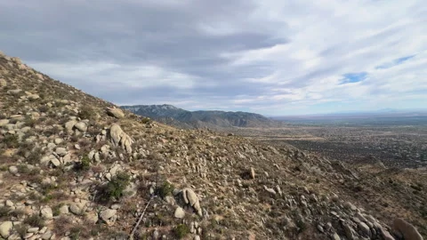 Aerial moving down rocky mountain, vast plains in distant, stock footage Stock Footage 308134138