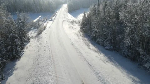 Aerial moving forward low above a snow covered road  Stock Footage 231229177