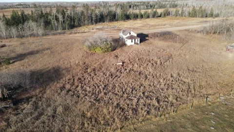 Aerial moving forward over a bleak looking dry scene with a small white house Stock Footage 220199787