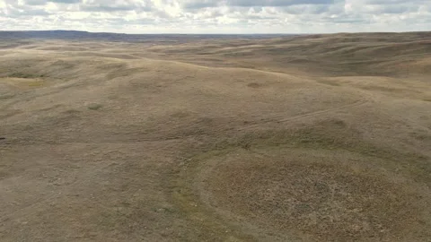 Aerial moving forward over dry rolling western ranch land with cattle trails.  Stock Footage 289028121
