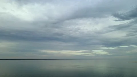 Aerial moving forward over a large lake under an extensive cloud filled sky Stock Footage 229801055