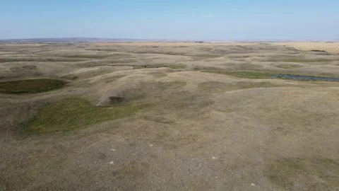 Aerial moving forward over rolling small dry hills in the open prairie  Stock Footage 257724097