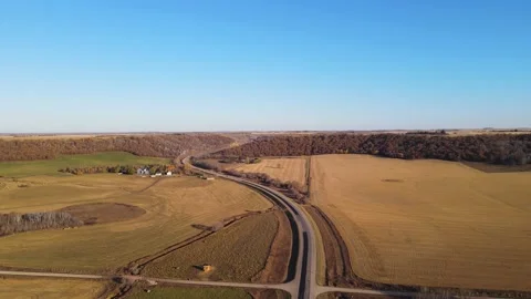 Aerial moving forward over a winding paved road surrounded by dry farmland  Stock Footage 219486652