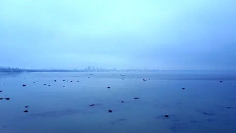 Aerial moving forward shot towards the city and sea. Misty cold winter sea. Stock Footage 100127399