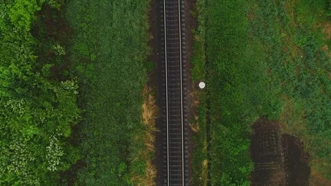 Aerial moving forward view of railtrack and a tourist walking along it, in Stock Footage 110714209