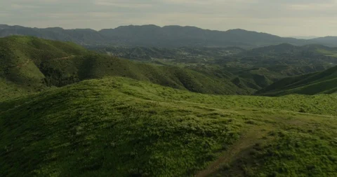 Aerial moving quickly forward over green hills, day 스톡 동영상 105380798